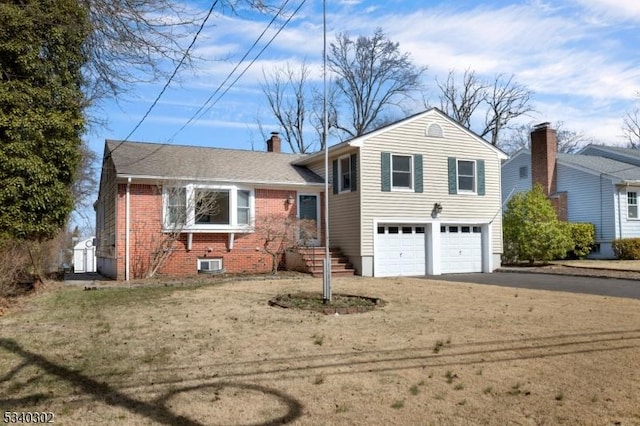 tri-level home with brick siding, central air condition unit, a chimney, a garage, and driveway