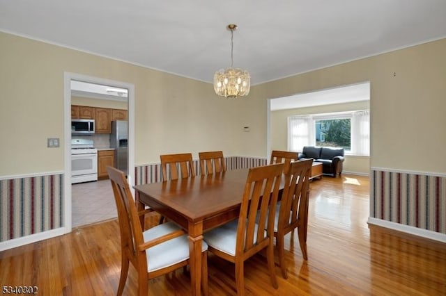 dining area with a chandelier and light wood-style flooring