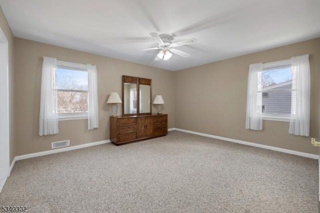 unfurnished bedroom with visible vents, a ceiling fan, baseboards, and carpet floors