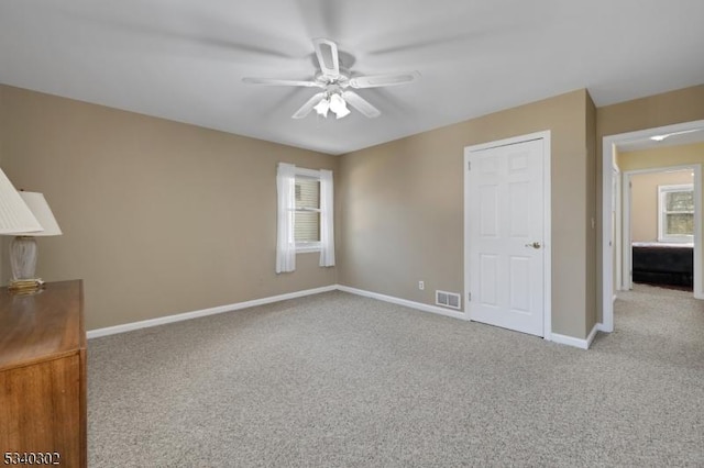 unfurnished bedroom with visible vents, baseboards, ceiling fan, and carpet flooring