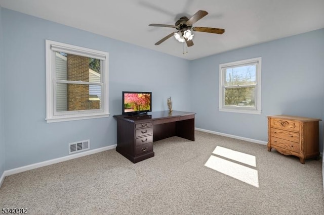 office area featuring visible vents, light colored carpet, a ceiling fan, and baseboards