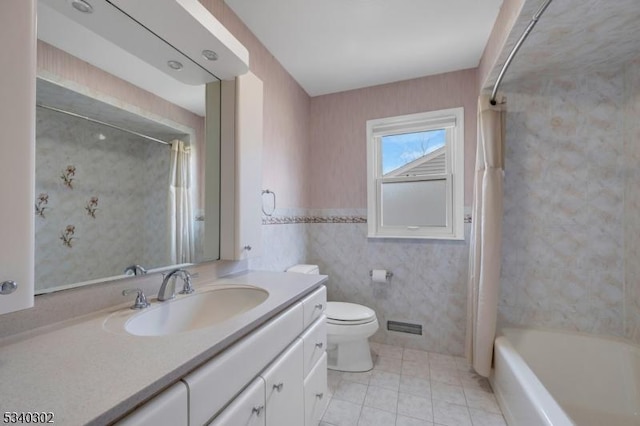 full bathroom featuring wallpapered walls, toilet, shower / tub combo, tile patterned floors, and vanity