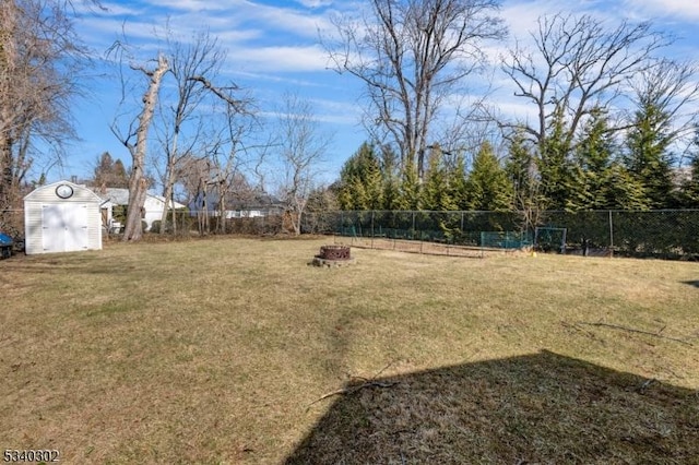 view of yard with an outdoor structure, a fenced backyard, and a shed