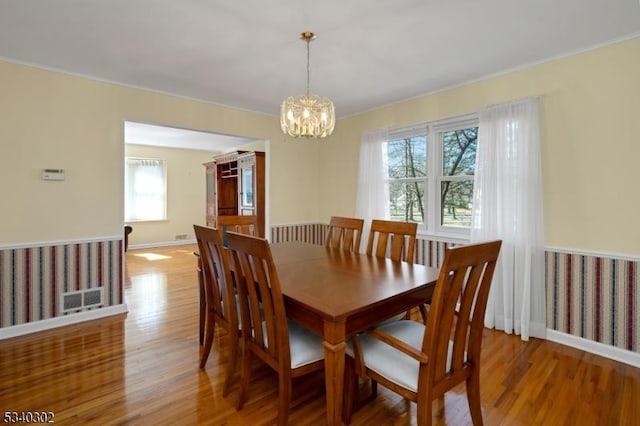 dining room featuring visible vents, baseboards, light wood-type flooring, and an inviting chandelier