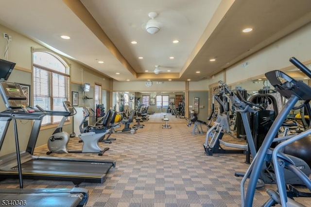 workout area featuring a tray ceiling, carpet, and recessed lighting