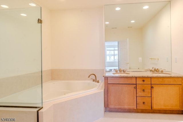 full bathroom featuring double vanity, a sink, a bath, and recessed lighting