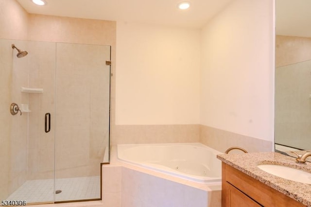 full bathroom featuring a tub with jets, a stall shower, vanity, and recessed lighting