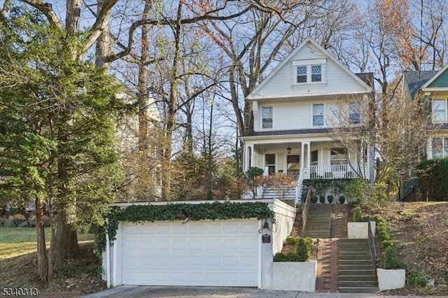 view of front of home with a garage, covered porch, and stairs