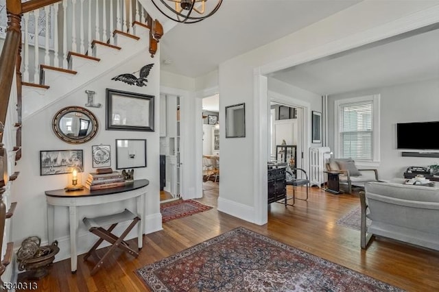 foyer featuring stairway, radiator, wood finished floors, and baseboards