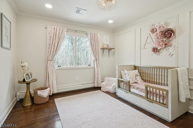 bedroom with a baseboard radiator, dark wood-type flooring, visible vents, baseboards, and a nursery area