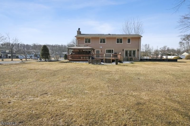 rear view of property with a chimney, a lawn, and a gazebo