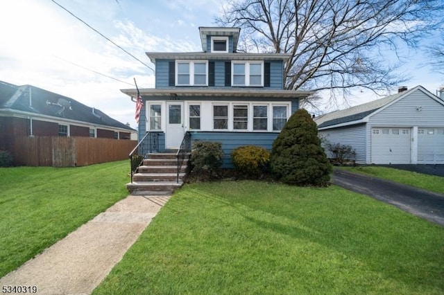 american foursquare style home with an outdoor structure, fence, a detached garage, and a front yard