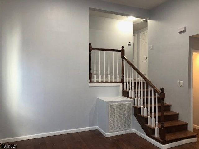 stairs with visible vents, baseboards, and wood finished floors