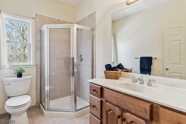 bathroom with a stall shower, tile patterned flooring, vanity, and toilet