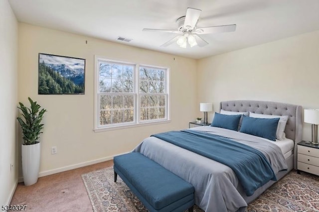 carpeted bedroom featuring ceiling fan, visible vents, and baseboards