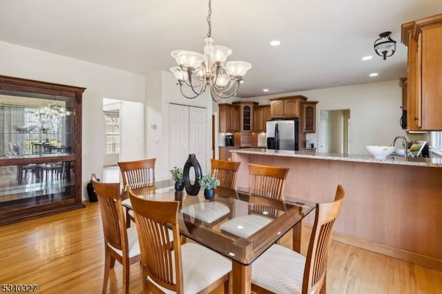 dining space featuring recessed lighting, light wood-style flooring, and an inviting chandelier