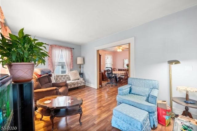 living area featuring baseboards and wood finished floors