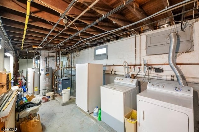 below grade area with washer and clothes dryer, gas water heater, and freestanding refrigerator