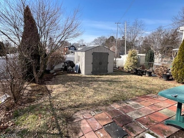 view of yard with a storage shed, a fenced backyard, a patio, and an outdoor structure