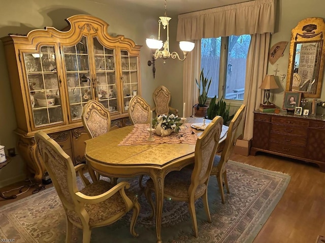 dining space with a chandelier and wood finished floors