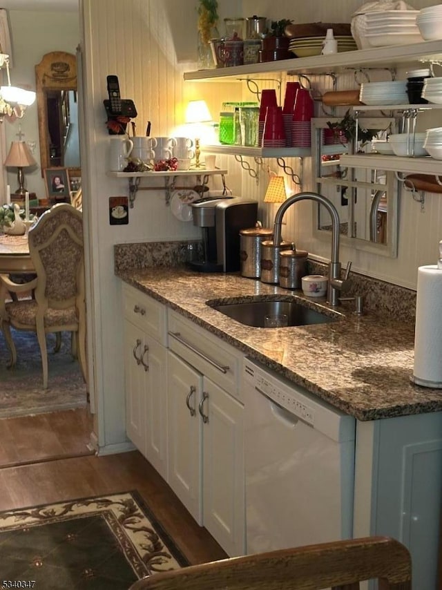 kitchen with white dishwasher, a sink, white cabinetry, light wood-style floors, and open shelves