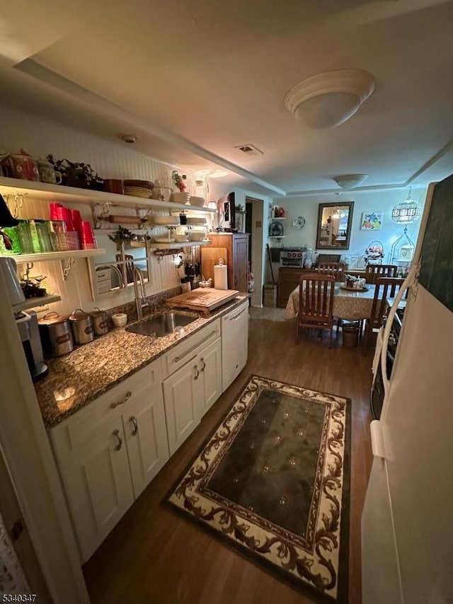 kitchen with open shelves, stone countertops, white cabinets, a sink, and wood finished floors