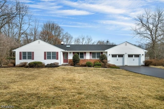 ranch-style home with aphalt driveway, a front lawn, and an attached garage