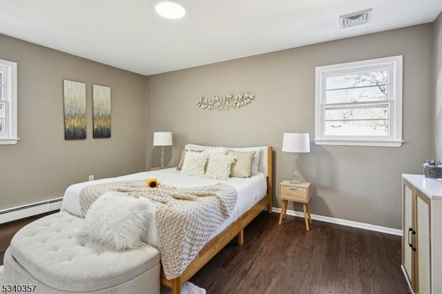 bedroom with dark wood-type flooring, a baseboard radiator, visible vents, and baseboards