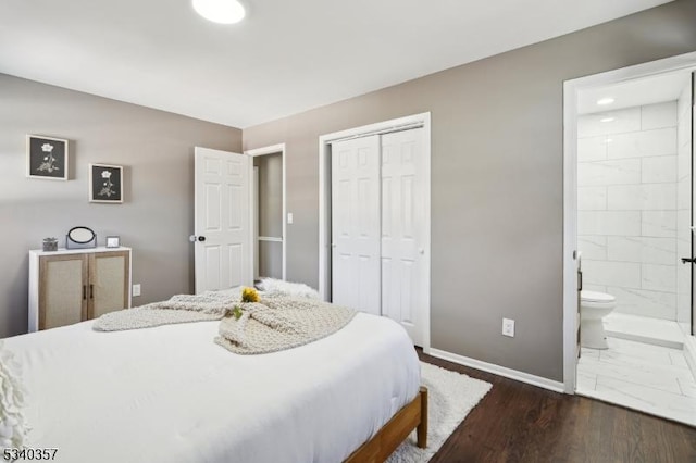 bedroom with dark wood-type flooring, a closet, baseboards, and ensuite bathroom