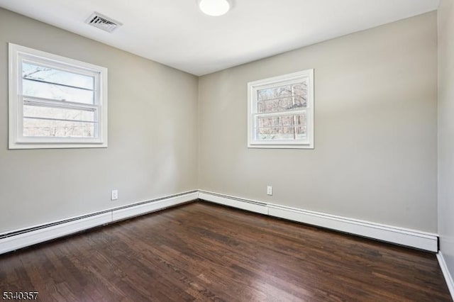 unfurnished room featuring a baseboard radiator, visible vents, and wood finished floors