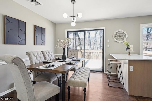 dining room featuring dark wood-style floors, visible vents, and baseboards