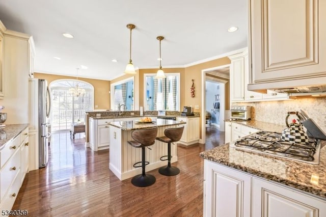 kitchen with a wealth of natural light, decorative backsplash, a breakfast bar area, and stainless steel appliances