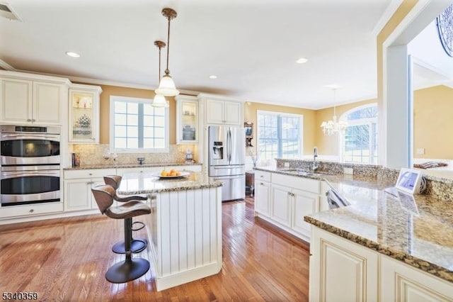 kitchen featuring a sink, light wood-style floors, a wealth of natural light, and stainless steel appliances