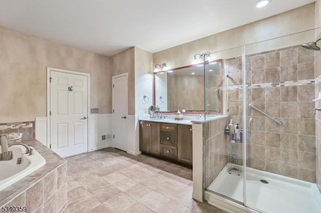 bathroom with visible vents, a shower stall, vanity, and a garden tub