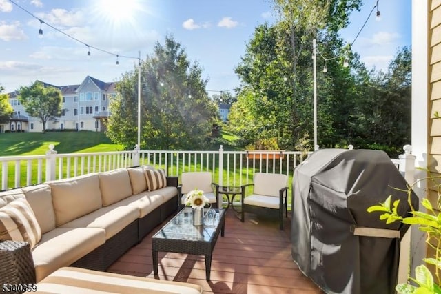 wooden terrace featuring an outdoor living space, a yard, and grilling area