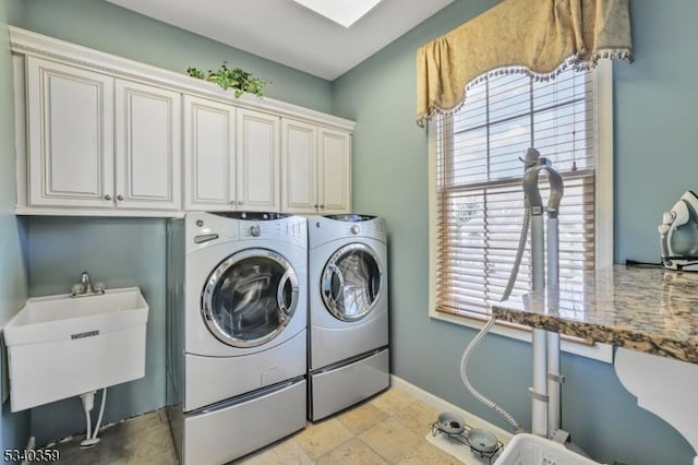 laundry area featuring a sink, baseboards, cabinet space, and independent washer and dryer