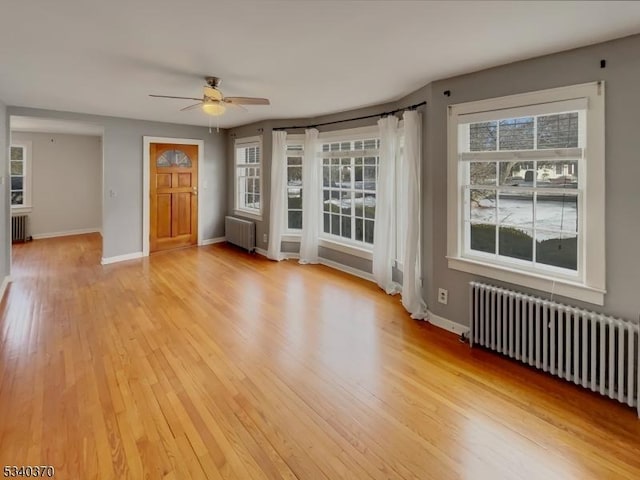 interior space with light wood finished floors, radiator heating unit, plenty of natural light, and radiator