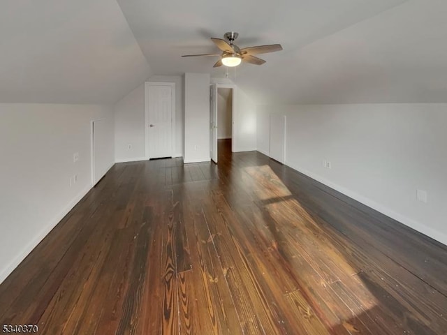 additional living space with lofted ceiling, ceiling fan, baseboards, and dark wood-style flooring