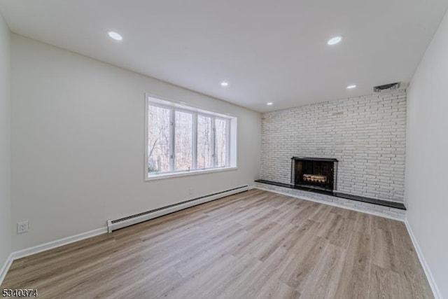 unfurnished living room with a baseboard radiator, recessed lighting, baseboards, light wood-type flooring, and a brick fireplace