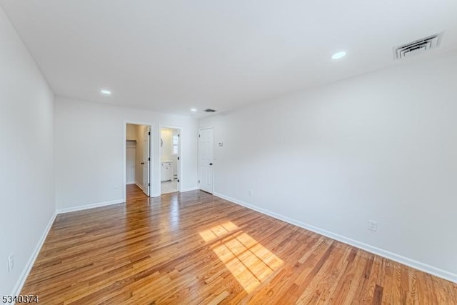 spare room with recessed lighting, wood finished floors, visible vents, and baseboards