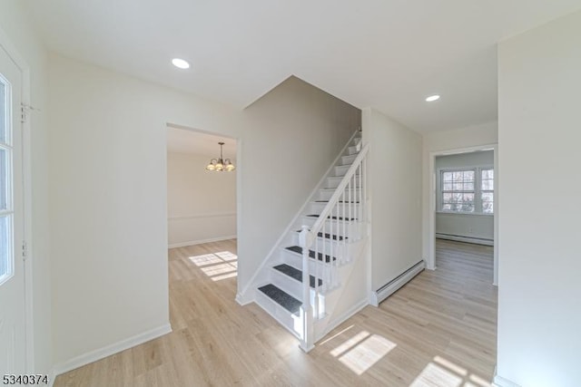 stairs with a baseboard radiator, wood finished floors, an inviting chandelier, a baseboard heating unit, and recessed lighting