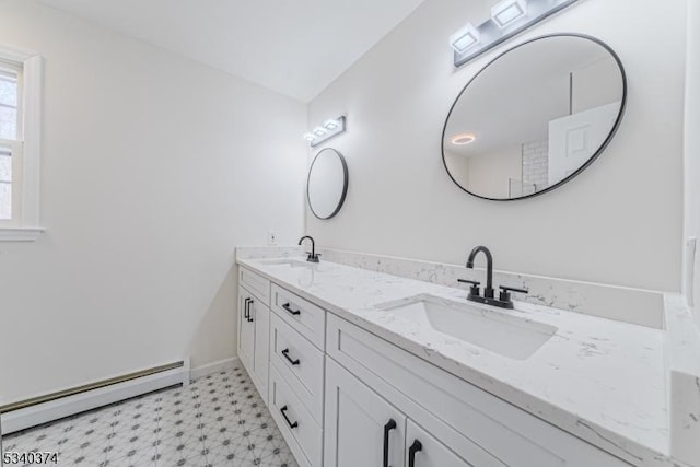 full bath featuring double vanity, a baseboard heating unit, a sink, and tile patterned floors