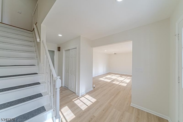 stairway with recessed lighting, wood finished floors, and baseboards