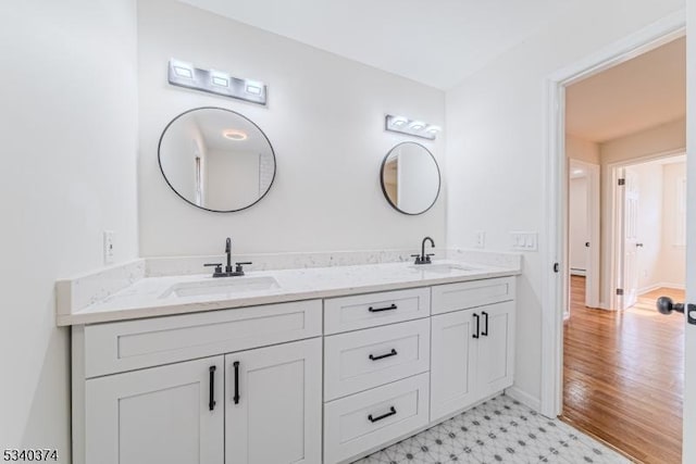 bathroom with double vanity, baseboards, a sink, and tile patterned floors