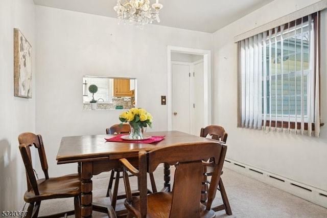 dining area featuring a baseboard heating unit, a chandelier, and carpet flooring