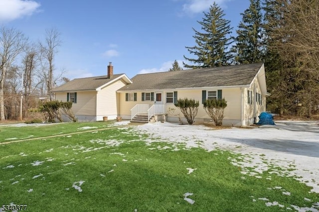 rear view of house with a chimney and a lawn