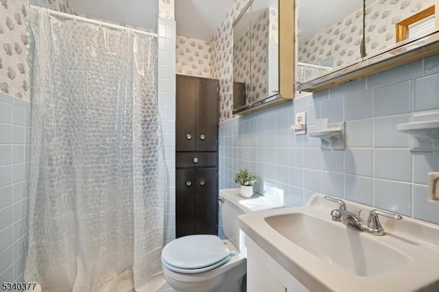 full bathroom featuring toilet, vanity, tile walls, and wallpapered walls