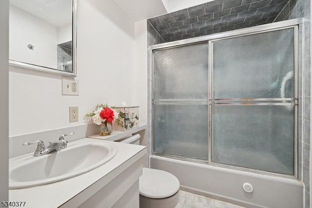 full bathroom with toilet, bath / shower combo with glass door, and vanity