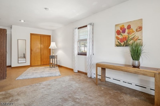 sitting room featuring carpet, baseboards, and baseboard heating