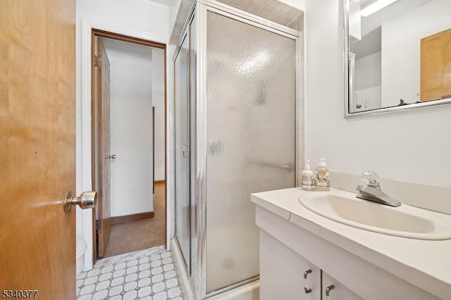 bathroom with a stall shower, vanity, and tile patterned floors